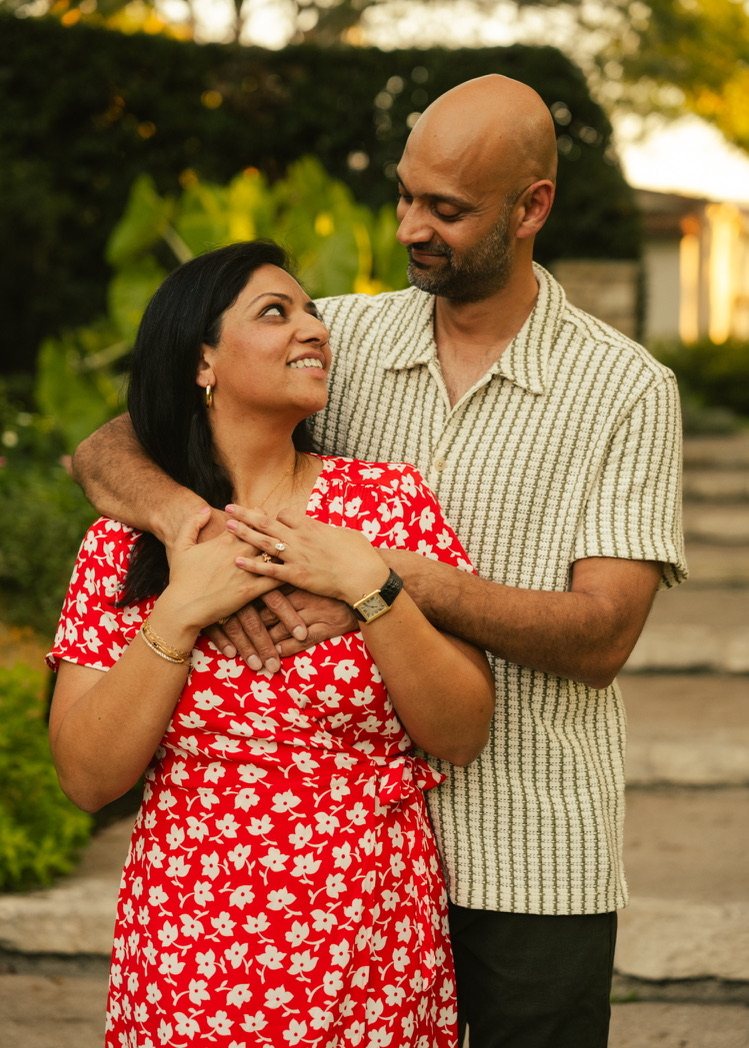 Krishna smiling up at Harsh as he holds her